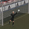 A goalkeeper reaches out for a football flying towards his goals.